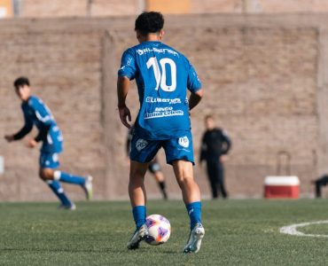 Soccer player wearing number 10 blue jersey during a match on a sunny day.
